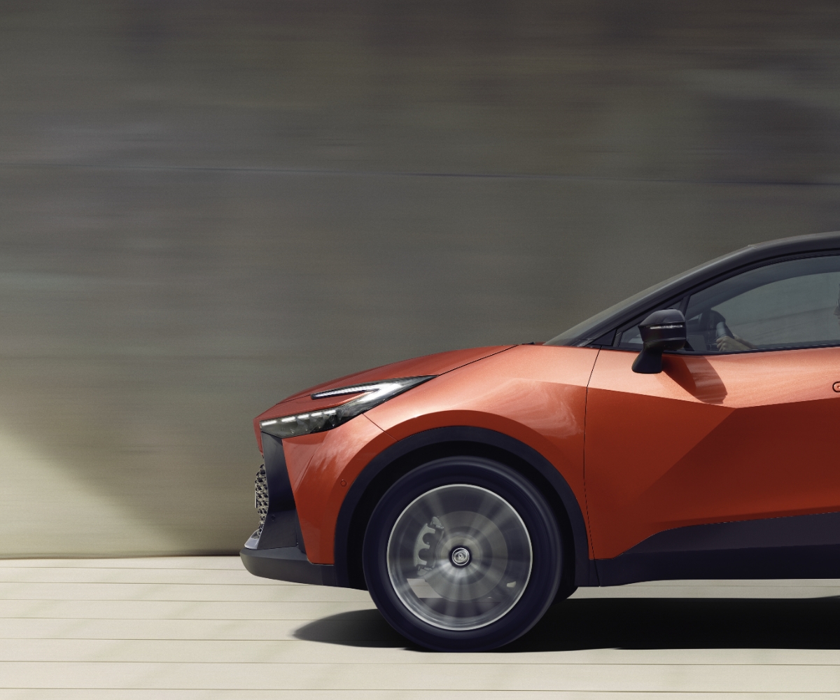 Pomarańczowa Toyota jedzie drogą